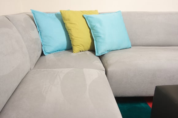 Grey couch with blue and yellow pillows